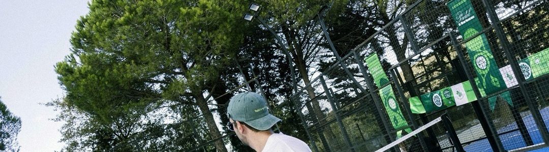 Mavi padel kortunda raketiyle oyuna hazırlanan sporcu.